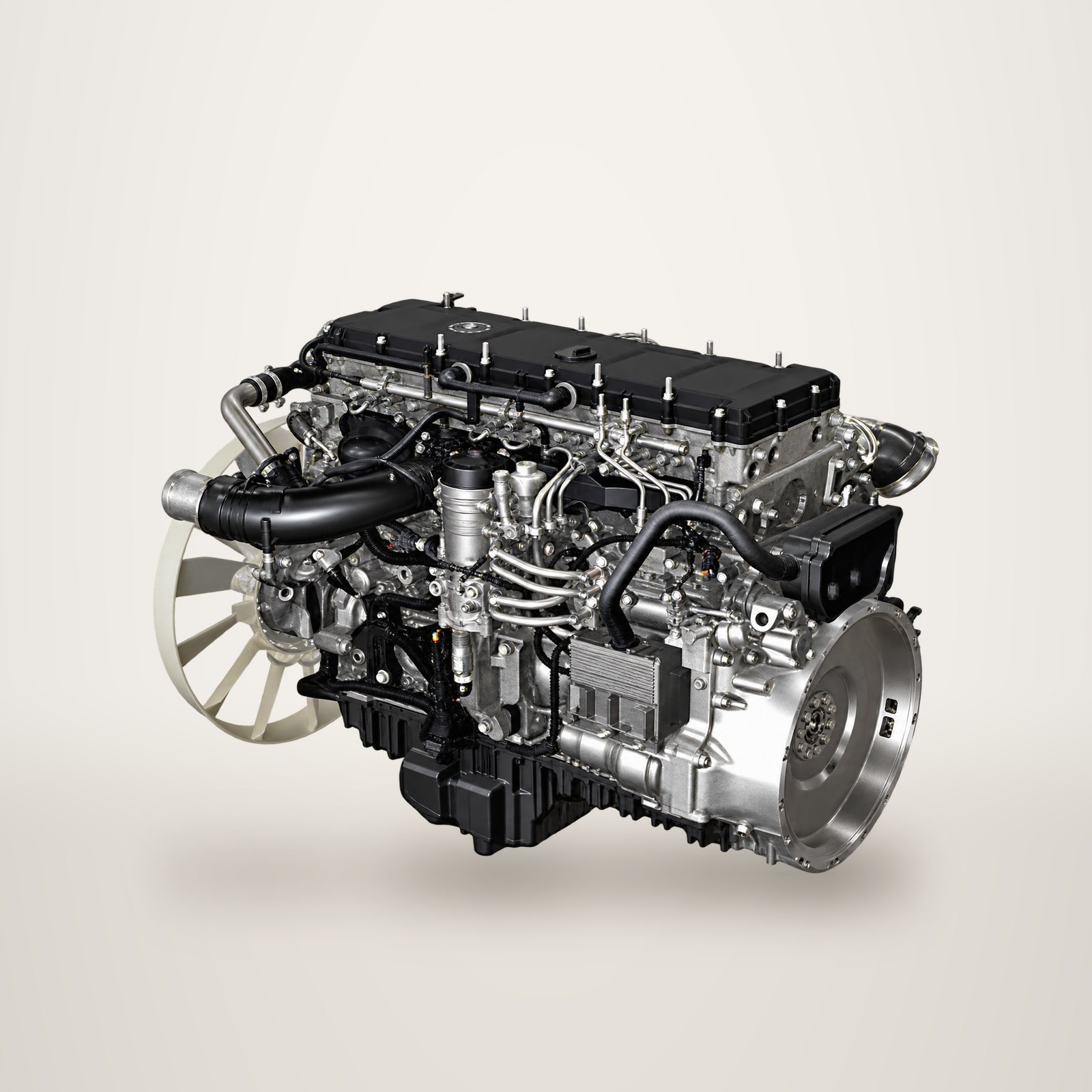 Un moteur diesel de poids lourd avec turbocompresseur, tuyauteries et ventilateur, photographié seul sur fond blanc.